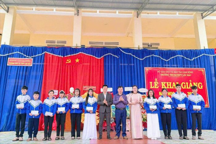 Ông Lê Xuân Vũ, Phó Chủ tịch UBND xã Bảo Lâm 5 (thứ 7 từ trái qua) trao học bổng cho các em học sinh
