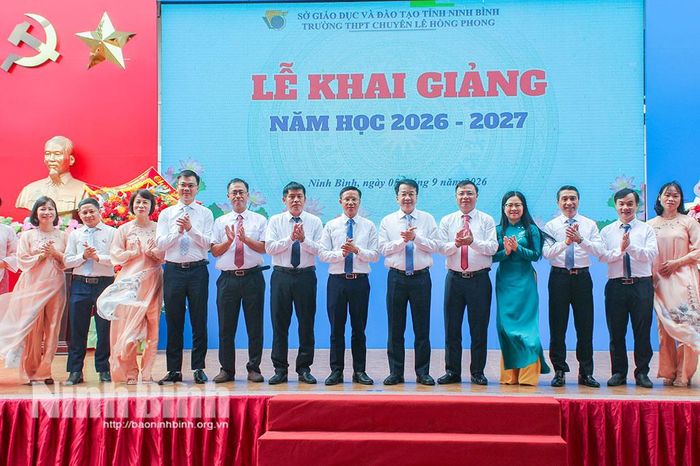Đồng chí Chủ tịch UBND tỉnh Nguyễn Thanh Bình và các đại biểu chụp ảnh lưu niệm với cán bộ, giáo viên Trường THPT chuyên Lê Hồng Phong.