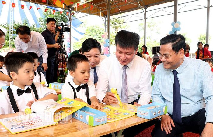 Đồng chí Trần Huy Tuấn, Ủy viên Trung ương Đảng, Bí thư Tỉnh ủy hướng dẫn các cháu Trường Mầm non Hoa Lư sử dụng bộ sách học tiếng Anh.