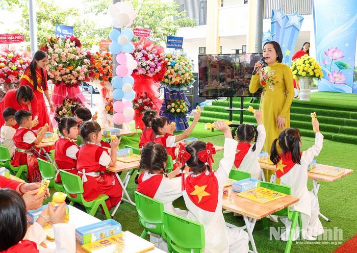 Đồng chí Nguyễn Thị Thanh, Ủy viên Trung ương Đảng, Phó Chủ tịch Quốc hội hướng dẫn các cháu Trường Mầm non Hoa Lư sử dụng bộ sách học tiếng Anh.