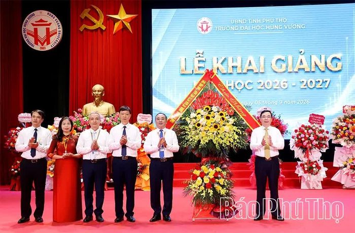 Phó Bí thư Tỉnh ủy Bùi Huy Vĩnh tặng hoa chúc mừng thầy và trò Trường Đại học Hùng Vương nhân dịp khai giảng năm học mới.