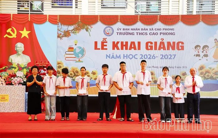 Đồng chí Bùi Đức Hinh cùng Chủ tịch Hội Khuyến học tỉnh trao quà của Hội Khuyến học tỉnh tặng các em học sinh.