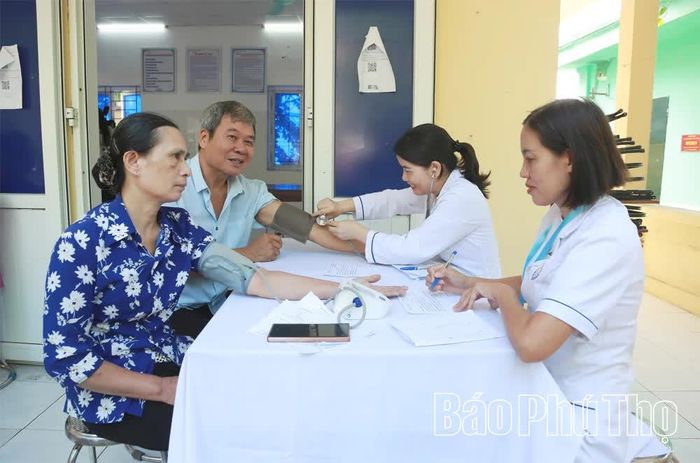 Người dân đến khám bệnh tại Trạm y tế xã Nguyệt Đức được bác sĩ đo huyết áp, kiểm tra sức khỏe.