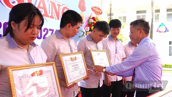 Đại diện lãnh đạo nhà trường trao giấy khen và phần thưởng cho 16 học sinh đạt thành tích cao trong học tập và rèn luyện năm học 2025-2026 - Ảnh: H.T