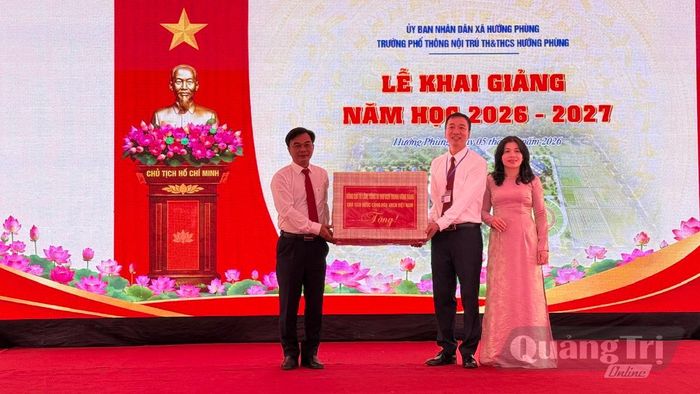 Đồng chí Nguyễn Chiến Thắng, Phó Bí thư Tỉnh ủy, Chủ tịch Ủy ban MTTQ Việt Nam tỉnh trao quà của đồng chí Tổng Bí thư, Chủ tịch nước Tô Lâm tặng tập thể lãnh đạo, giáo viên và nhân viên nhà trường - Ảnh: N.L