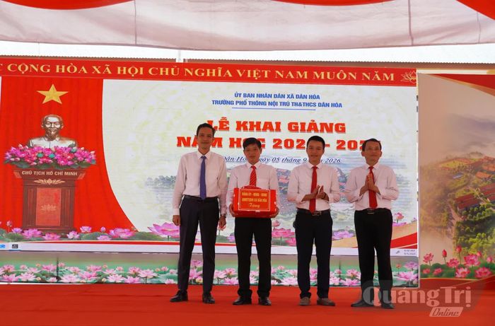 Đại diện lãnh đạo xã Dân Hóa trao quà chúc mừng năm học mới cho nhà trường - Ảnh: X.P