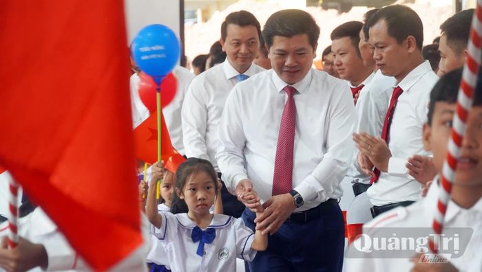 Đồng chí Trần Vũ Khiêm, Phó Bí thư Thường trực Tỉnh ủy, Trưởng đoàn đại biểu Quốc hội tỉnh đón các cháu học sinh vào lớp 1 - Ảnh: N.M