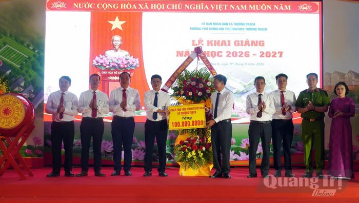 Đại diện lãnh đạo xã Thượng Trạch tặng quà cho thầy và trò nhà trường - Ảnh: N.M