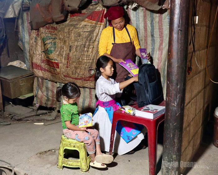 Em Dinh Thị Dàng, thôn Lũng Táo, xã Lũng Cú được mẹ dậy sớm sửa soạn quần áo, sách vở để chuẩn bị khai giảng năm học mới. Ảnh: Diệu Linh