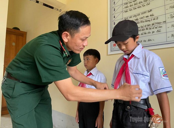Cán bộ, chiến sĩ Đồn Biên phòng Cửa khẩu Săm Pun chỉnh trang quần áo, đưa “con nuôi” đến trường ngày khai giảng năm học mới. Ảnh: Thảo Nguyên