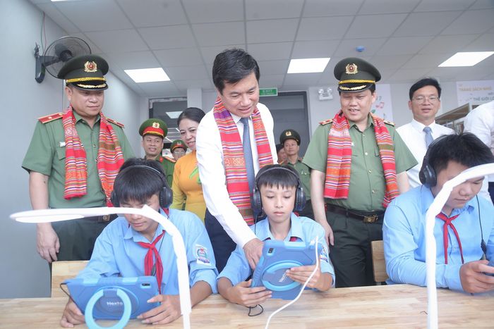 Thứ trưởng Bộ Xây dựng Nguyễn Tường Văn cùng các em học sinh trải nghiệm các thiết bị học tập hiện đại trong thư viện điện tử.