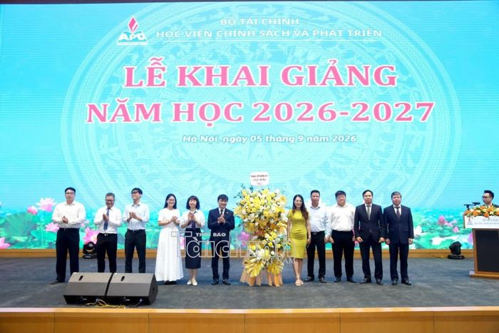 Đại diện các tân sinh viên, nghiên cứu sinh, thạc sỹ tặng hoa Ban giám đốc Học viện Chính sách và Phát triển. Ảnh: Đức Minh