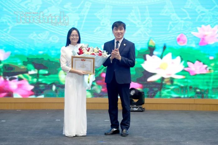 NGƯT. PGS. TS. Trần Trọng Nguyên - Giám đốc Học viện Chính sách và Phát triển trao giấy khen cho thủ khoa khóa 17 Trần Thị Tú Trinh. Ảnh: Đức Minh