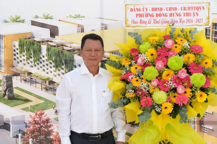 Hiệu trưởng Trường THPT Phan Văn Hớn Nguyễn Duy Bình nhận hoa chúc mừng từ lãnh đạo địa phương. Ảnh: Thạc Hiếu