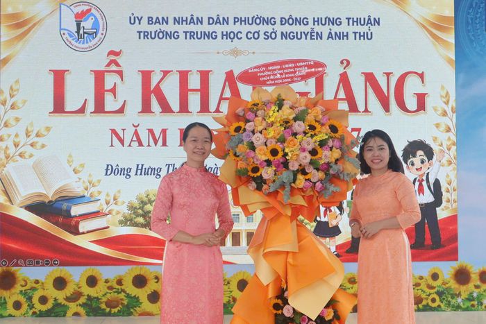 Hiệu trưởng Trường THCS Nguyễn Ảnh Thủ Lê Thị Tuyết Nhung nhận hoa chúc mừng từ lãnh đạo phường Đông Hưng Thuận. Ảnh: Thạc Hiếu