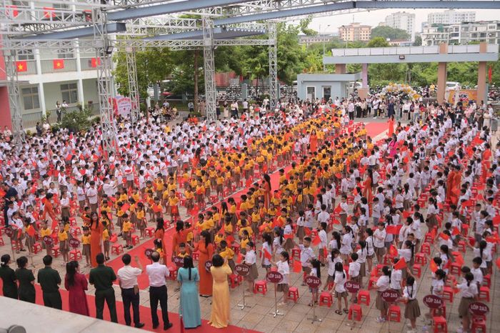 Ngay từ sáng sớm, các sân trường đã ngập tràn sắc màu đồng phục, cờ hoa và những gương mặt háo hức. Phụ huynh đưa con đến trường, thầy cô đứng đón học sinh, còn những cô cậu học trò ríu rít gọi tên nhau sau những ngày hè xa cách.