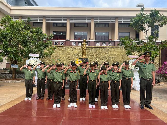 Giáo viên và học sinh chụp hình tại Tượng đài Anh hùng liệt sĩ Võ Thị Sáu trong khuôn viên trường.