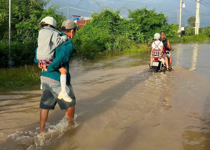 Một số người dân trực tiếp cõng các em qua đoạn nước sâu.