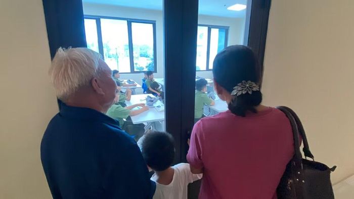 Người thân đứng bên ngoài cửa lớp theo dõi con em mình trong tiết học đầu tiên.