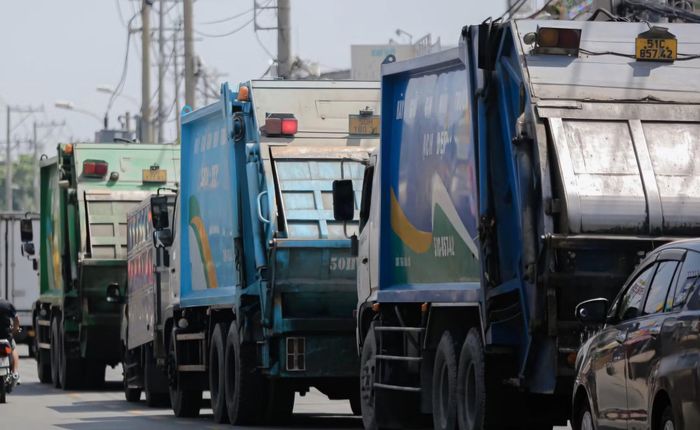 Xe chở rác đậu chờ ngoài đường để được vào bãi rác Đa Phước.