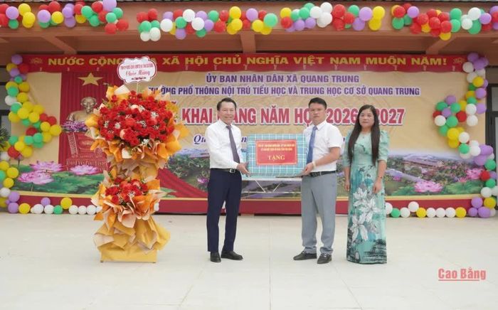 Phó Chủ tịch Thường trực UBND tỉnh Lương Tuấn Hùng tặng hoa và quà của tỉnh chúc mừng Trường Phổ thông nội trú Tiểu học và THCS Quang Trung.