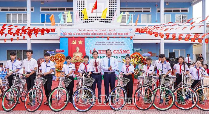  Phó Chủ tịch Thường trực UBND tỉnh Lâm Văn Bi và Bí thư Đảng uỷ, Chủ tịch HĐND xã Đất Mũi Kiều Minh Tiếng trao xe đạp cho học sinh có hoàn cảnh khó khăn trên địa bàn xã.