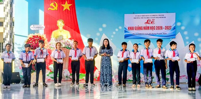 Đồng chí Nguyễn Cẩm Tú, Bí thư Đảng uỷ xã Phong Thạnh, trao học bổng cho học sinh.