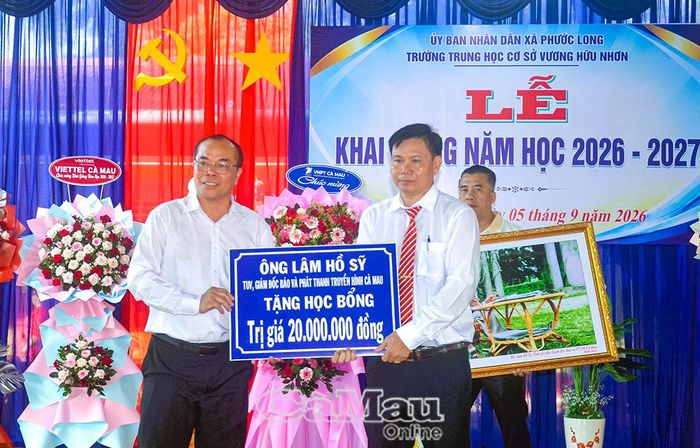 Đồng chí Lâm Hồ Sỹ, Giám đốc Báo và phát thanh, truyền hình Cà Mau (bên trái), trao bảng tượng trưng tặng học bổng trị giá 20 triệu đồng cho học sinh có hoàn cảnh khó khăn.