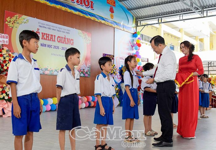 Đồng chí Nguyễn Thế Châu, Bí thư Đảng uỷ Xã Trần Văn Thời, trao học bổng cho học sinh hoàn cảnh khó khăn đạt thành tích tốt trong học tập.