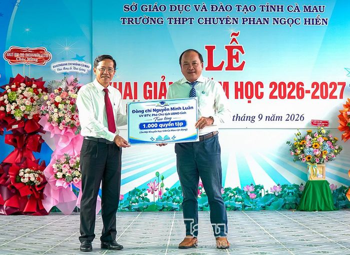 Dịp này, Phó Giám đốc Sở Giáo dục và Đào tạo Tạ Thanh Vũ (bên trái) trao 1.000 quyển tập do đồng chí Nguyễn Minh Luân, Uỷ viên Ban Thường vụ Tỉnh uỷ, Phó Chủ tịch UBND tỉnh, tặng nhà trường nhân dịp năm học mới.
