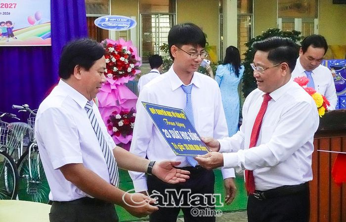 Phó Chủ tịch HĐND tỉnh Bùi Tấn Bảy trao bảng tượng trưng 20 suất học bổng từ Quỹ Khuyến học Võ Văn Kiệt cho Trường THCS Lê Hồng Phong.