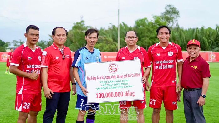 Đồng chí Bùi Thanh Toàn, Bí thư Đảng uỷ, Chủ tịch HĐND phường Láng Tròn, tỉnh Cà Mau (áo xanh), nhận bảng tượng trưng 100 triệu đồng học bổng do Đội bóng cán bộ, công chức Thành phố Hồ Chí Minh tặng sinh viên Cà Mau đang học tập tại thành phố.