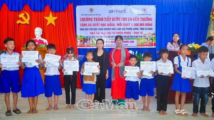 Bà Nguyễn Thị Ánh Tuyết, Phó Trưởng ban Từ thiện xã hội Phật giáo tỉnh Cà Mau (bên phải) và đại diện Hội Từ thiện IPACE (Thuỵ Sĩ) trao học bổng cho học sinh hoàn cảnh khó khăn tại xã Phước Long.