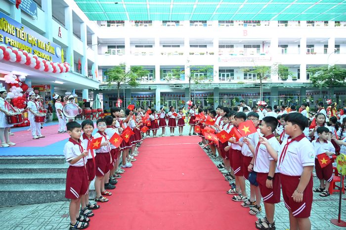 Trên tay mỗi em cầm một lá cờ Tổ quốc do Nhà trường chuẩn bị trước