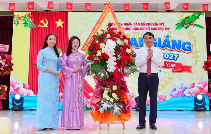 Phó Chủ tịch UBND thành phố Nguyễn Xuân Lưu tặng hoa chúc mừng thầy, cô và học sinh Trường THCS Chuyên Mỹ bước vào năm học mới. Ảnh: Hồng Thái