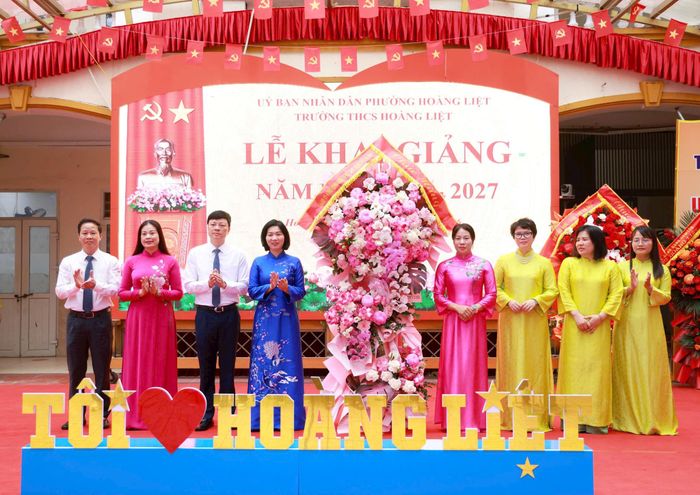Chủ tịch HĐND thành phố Phùng Thị Hồng Hà trao tặng tập thể cán bộ, giáo viên Trường THCS Hoàng Liệt lẵng hoa tươi thắm chào mừng năm học mới 2026-2027. Ảnh: Văn Tuyến