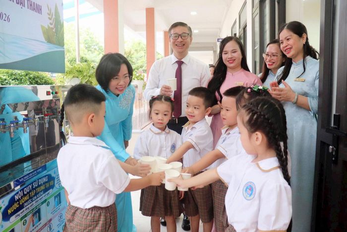 Chủ tịch Ủy ban MTTQ Việt Nam thành phố Hà Nội Bùi Huyền Mai cùng lãnh đạo xã Đại Thanh và thầy trò Trường Tiểu học Vương Thừa Vũ chung vui cùng các học sinh tại hệ thống nước tập trung. Ảnh: Hiền Chi