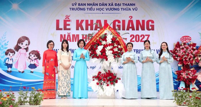 Chủ tịch Ủy ban MTTQ Việt Nam thành phố Hà Nội Bùi Huyền Mai tặng hoa chúc mừngthầy trò Trường Tiểu học Vương Thừa Vũ. Ảnh: Hiền Chi