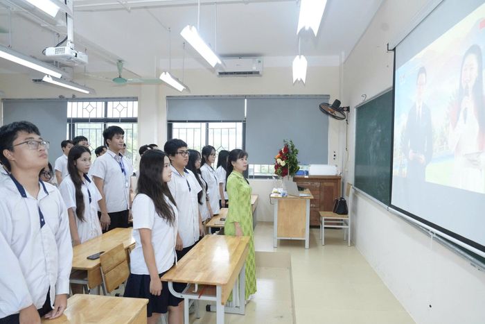Học sinh Trường THPT chuyên Nguyễn Huệ làm lễ chào cờ cùng các điểm cầu trên cả nước. Ảnh: Phạm Hùng