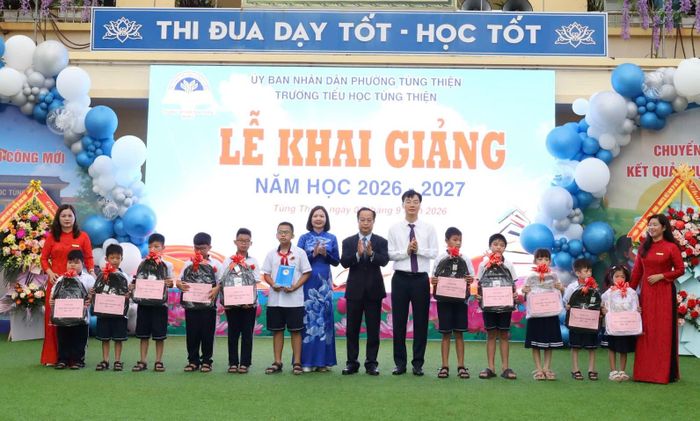 Lãnh đạo Thành phố cùng các đồng chí lãnh đạo phường Tùng Thiện, Nhà trường tặng quà động viên học sinh có hoàn cảnh khó khăn. Ảnh: Thu Huyền