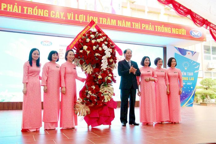 Trưởng ban Tuyên giáo Thành ủy Hà Nội Nguyễn Doãn Toản trao tặng lẵng hoa của Thành ủy - HĐND - UBND - Ủy ban MTTQ Việt Nam thành phố Hà Nội tới tập thể Trường THCS Nguyễn Văn Huyên. Ảnh: Bảo Lâm