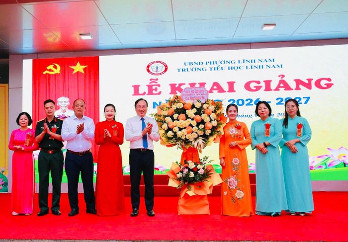 Đồng chí Đỗ Thanh Tùng, Bí thư Đảng ủy, Chủ tịch HĐND phường Lĩnh Nam cùng đoàn đại biểu tặng hoa chúc mừng và chụp ảnh lưu niệm với thầy và trò Trường Tiểu học Lĩnh Nam nhân dịp khai giảng năm học 2026-2027. Ảnh: LN