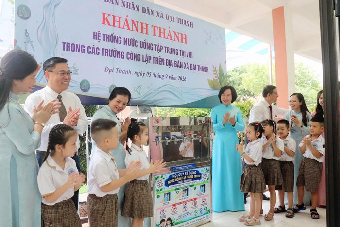 Chủ tịch Ủy ban MTTQ Việt Nam thành phố Hà Nội Bùi Huyền Mai cùng lãnh đạo xã Đại Thanh và thầy trò Trường Tiểu học Vương Thừa Vũ dự lễ khánh thành hệ thống nước tập trung tại vòi. Ảnh: Hiền Chi