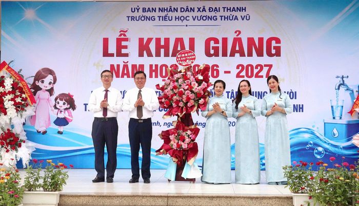 Lãnh đạo xã Đại Thanh tặng hoa chúc mừng Trường Tiểu học Vương Thừa Vũ. Ảnh: Hiền Chi