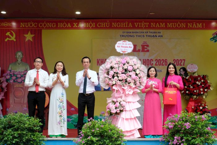 Chủ tịch UBND xã Thuận An Nguyễn Tuấn Khanh tặng hoa chúc mừng thầy và trò trường THCS Thuận An. Ảnh: Vân Thư
