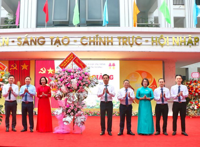 Trưởng Ban Tổ chức Thành ủy Hà Nội Vũ Đăng Định trao tặng lẵng hoa của Thành ủy - HĐND - UBND - Ủy ban MTTQ Việt Nam thành phố Hà Nội tới tập thể Trường THCS Trưng Vương. Ảnh: Hà Lan