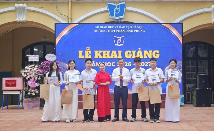 Nhà giáo Lê Ngọc Hoa, Bí thư Đảng ủy, Hiệu trưởng nhà trường khen thưởng các học sinh tiêu biểu. Ảnh Hải Hà.