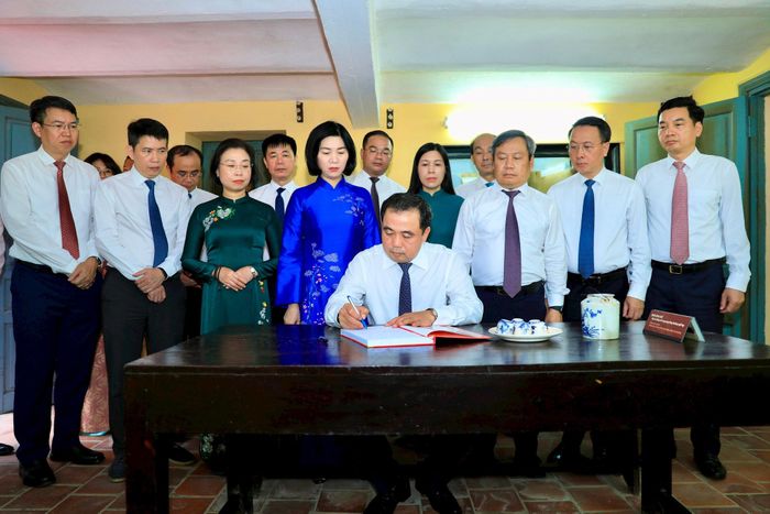 Bí thư Thành ủy Hà Nội Trần Đức Thắng viết lưu bút trong sổ vàng của Ban Quản lý di tích và danh thắng Hà Nội. Ảnh: Quang Thái