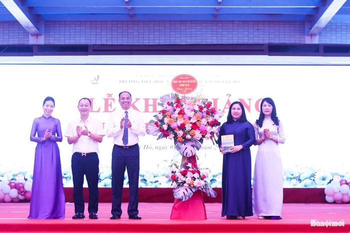 Bí thư Đảng uỷ, Chủ tịch HĐND phường Tây Hồ Nguyễn Đình Khuyến dự và tặng hoa chúc mừng trường Tiểu học và THCS Tây Hồ. Ảnh: Ngọc Tú