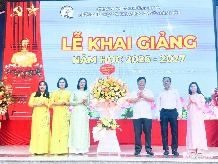 Chủ tịch UBND phường Tây Hồ Nguyễn Thanh Tịnh dự và tặng hoa chúc mừng trường Tiểu học và THCS Quảng Tân. Ảnh: Hà Phương